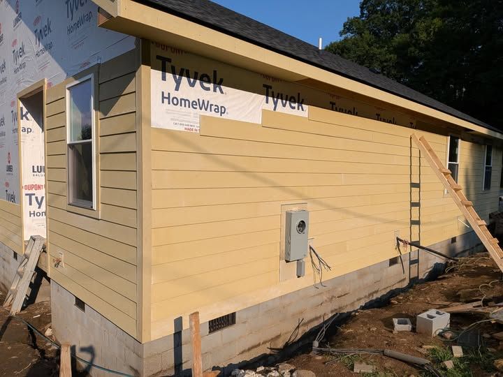 Side of a house with new yellow lap siding