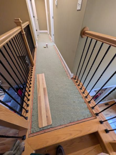 Upstairs hallway with carpet pulled back before flooring